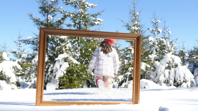 Mother and daughter playing in winter snow, frame in the foreground