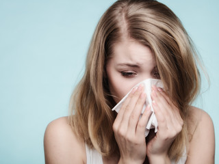 Flu allergy. Sick girl sneezing in tissue. Health