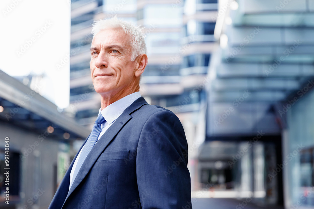 Wall mural Portrait of confident businessman outdoors