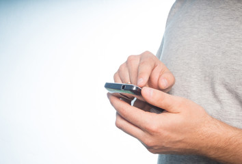 Young caucasian man in a gray t-shirt smartphone