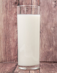 A fresh glass of fresh milk over wooden background