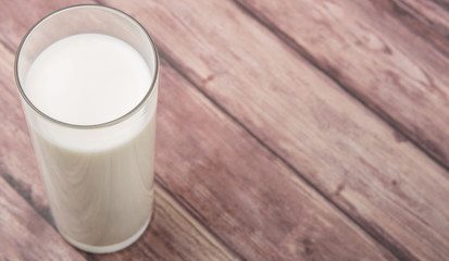 A fresh glass of fresh milk over wooden background