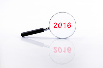 2016 word on Magnifying glass in a metal frame with rubber black