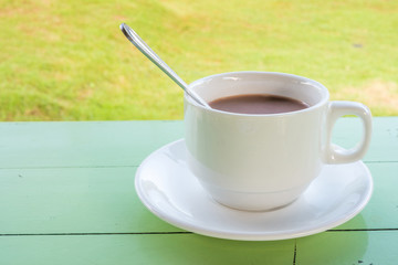 Ceramic cup of coffee on table in backyard. It is a drink for refreshment.