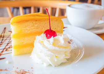 cherry topping on whipping cream served with cake