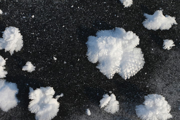 Snow freakish outgrowths on ice of the frozen river, a natural background
