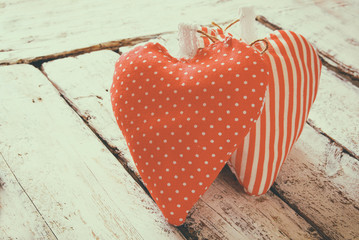 image of colorful fabric heart on wooden table. valentine's day celebration concept. retro filtered
