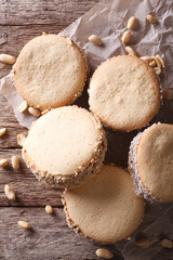 Tasty cookies with cream on paper close-up. vertical top view
