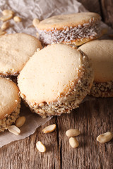 cookies alfajores with cream on paper close-up on the table. vertical