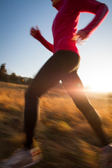 Fototapeta na wymiar Young woman running outdoors on a lovely sunny winter/fall day