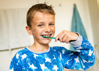 Young child brushing teeth with toothbrush