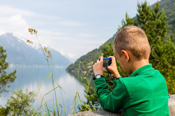 Boy taking picture with digital compact camera