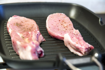 raw beef steak on black cooking grill pan