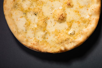 Pizza quattro formaggi with four kind of cheese served on wooden