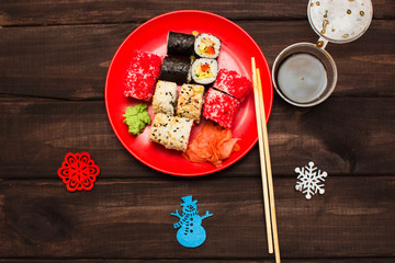 Fototapeta na wymiar delicious rolls and sushi. Christmas decor on a wooden board