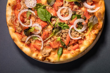 Pizza with tuna and vegetables served on wooden table