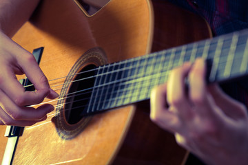 Young man playing acoustic guitar during a concert. - Vintage co