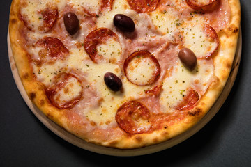 Hot spicy pizza with sausage, olives and mozzarela cheese served