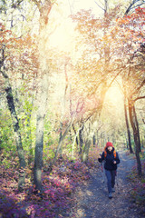Fototapeta premium The girl with the backpack walking in the forest.