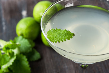 Cocktail margarita with limes and mint on the rustic background