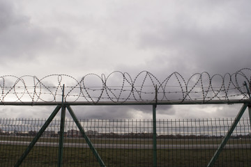 Barbed Wire Fence on Background of Gloomy Sky