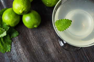Cocktail margarita with limes and mint on the rustic background