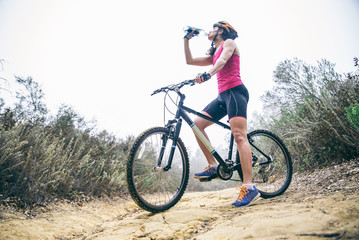Fototapeta na wymiar Woman drinking water on a bicycle