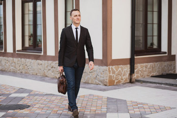 businessman walking on the street holding a briefcase in his hands
