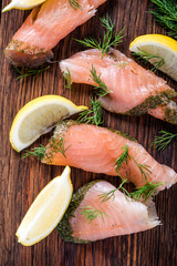 Smoked salmon on wooden board with dil and lemon