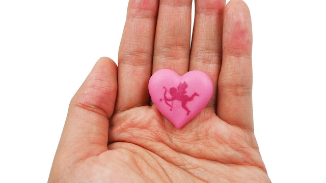 Pink heart with Cupid on woman's hand isolated on white background. Love and Valentines day concept.
