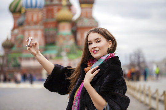 Young beautiful woman tourist taking pictures on mobile phone