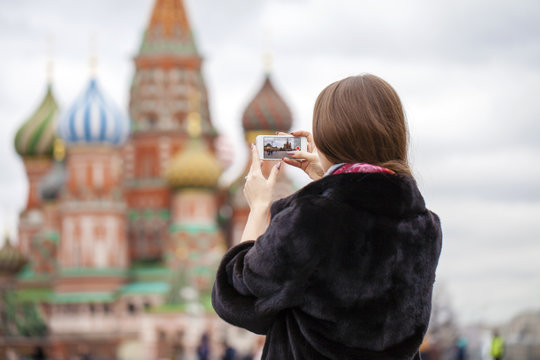 Young beautiful woman tourist taking pictures on mobile phone
