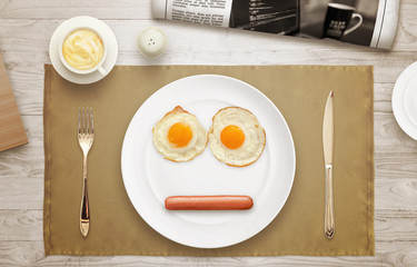 Breakfast plate face. Eggs, hot dog, plate, tablecloth, coffee, newspaper on table with a top view. 