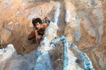 Top View of Rock Climber on orange Vertical Wall