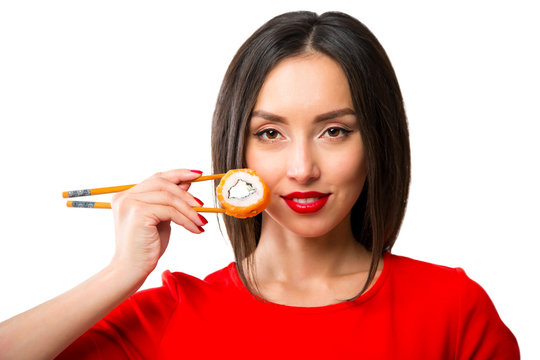 Young woman holding sushi with a chopsticks, isolated on white