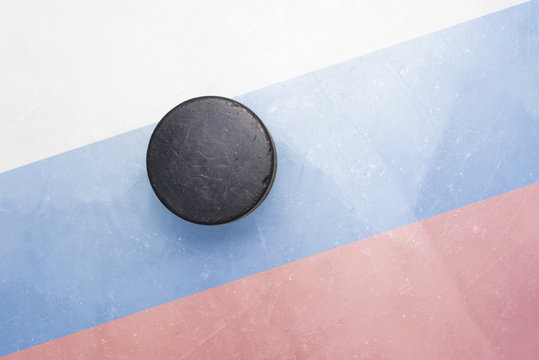 old hockey puck is on the ice with russia flag