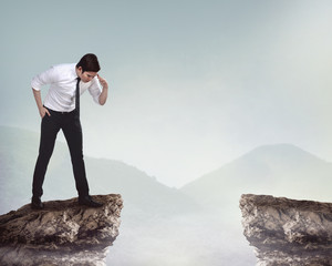 Business person looking down from top of the cliff