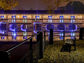 Night city of Strasbourg , the promenade lonely bench in the autumn of the city lights