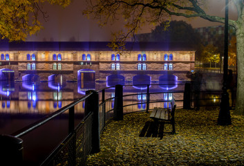 Night city of Strasbourg , the promenade lonely bench in the autumn of the city lights