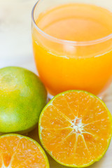 Glass of fresh tangerine, orange juice with sliced orange half o