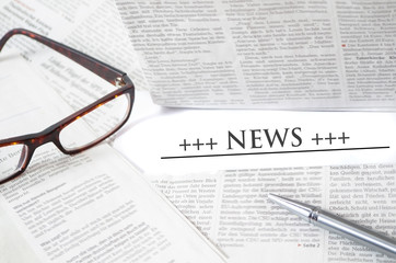 Zeitung, Brille, Stift