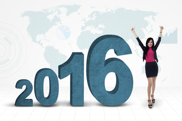 Happy businesswoman with numbers 2016 and map