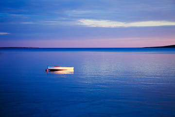 Seascape with White Boat in Blue Sea at Sunset