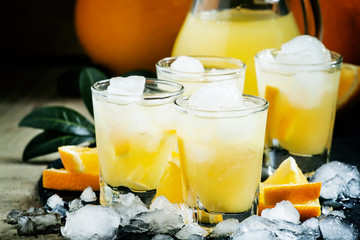 Orange soft drink with juice, vodka and ice, selective focus
