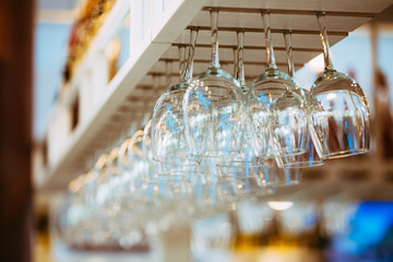Glasses hanging above bar rack.