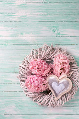 Pink  hyacinths flowers on wreath and decorative heart on turquo