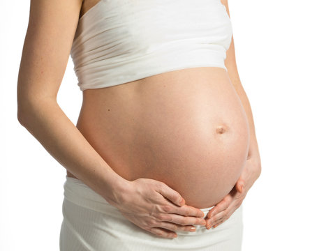 Pregnant woman's belly and hands around the abdomen, white background