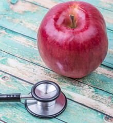 Medical stethoscope with an apple. Healthy lifestyle concept image.