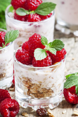 Fresh ripe raspberries with homemade yogurt, mint and muesli on