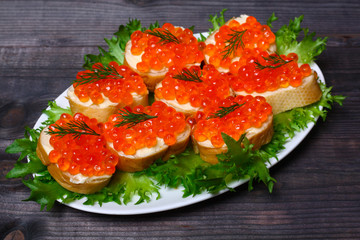 sandwiches with red caviar on a wooden background